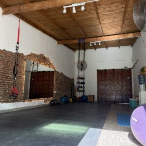 Sala de movimiento de Eirá con techo de madera y pared de ladrillo